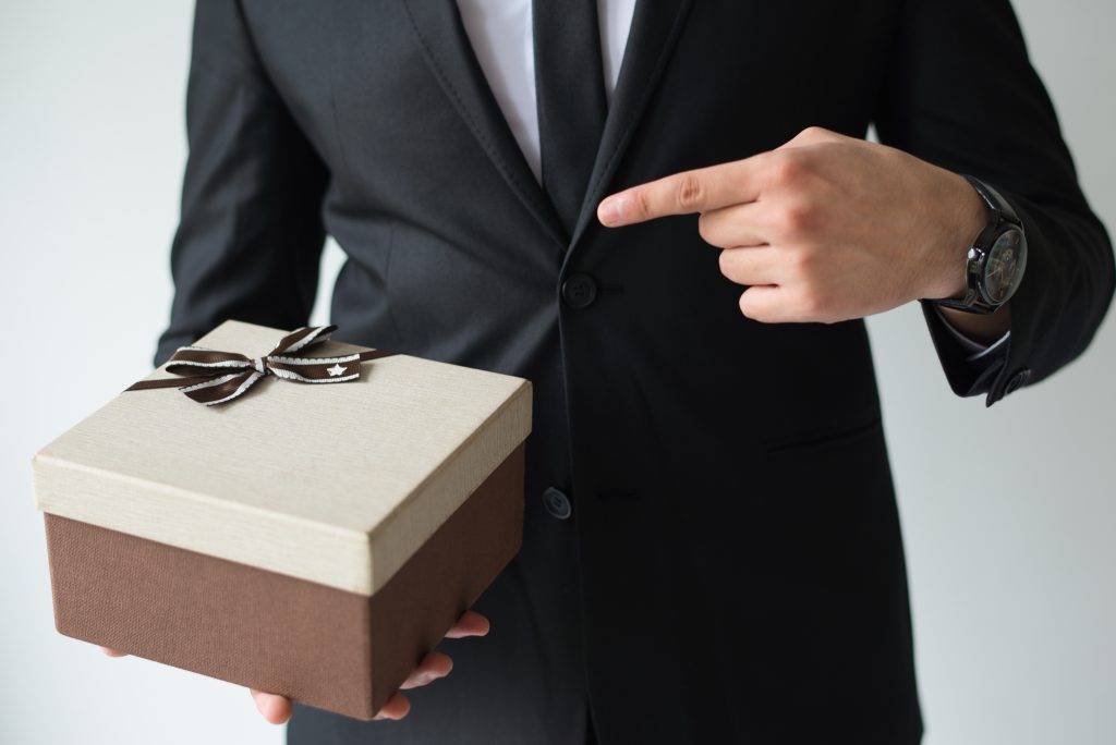 unrecognizable businessman holding brown gift box